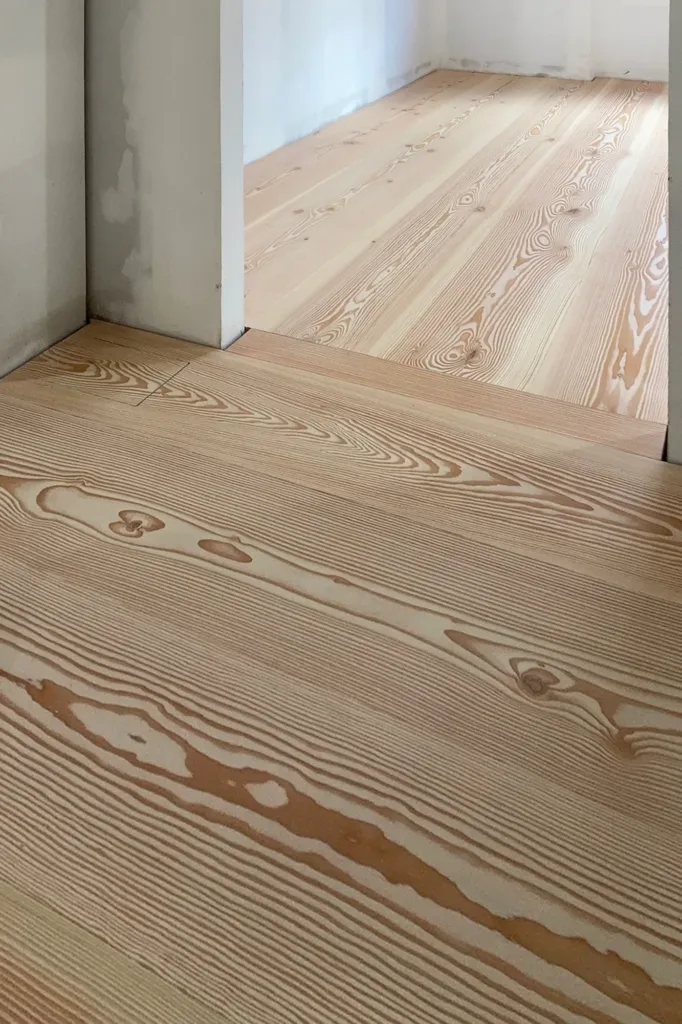 Paso entre estancias con tabla de cruce perpendicular en el suelo Dinesen Douglas, vivienda del centro de Murcia