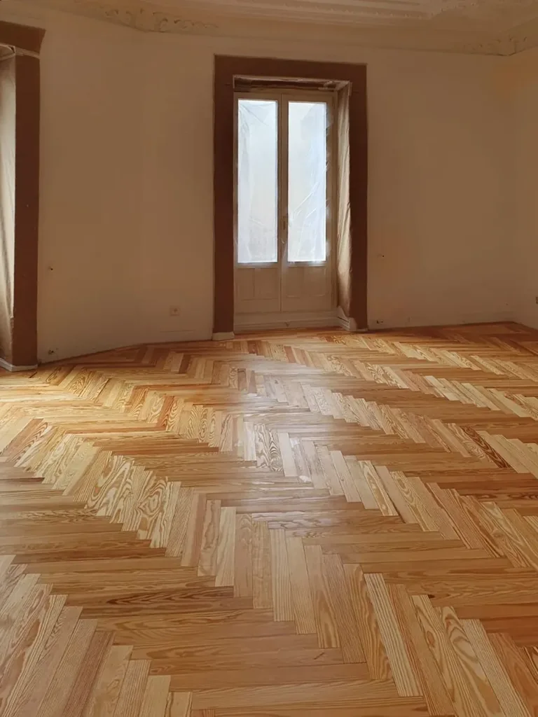 Dormitorio con suelo de espiga de pino melis viejo barnizado, vivienda en Chamberí (Madrid)