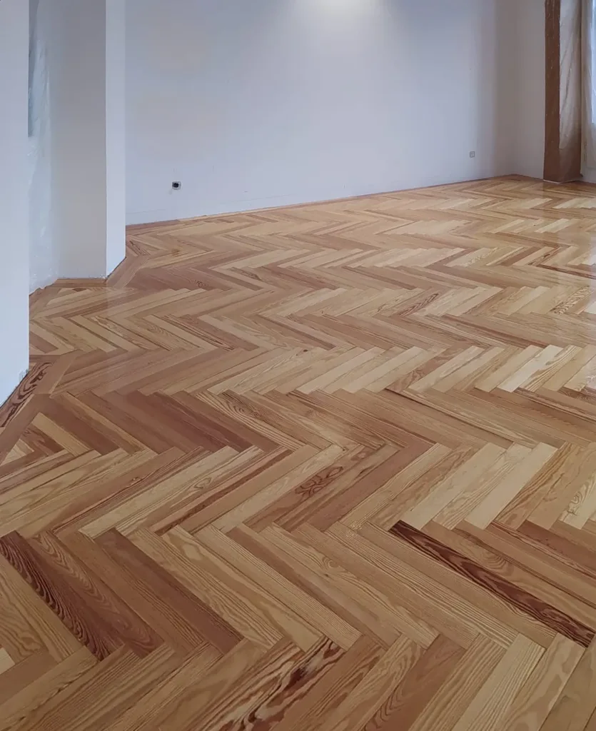 Primera mano de barniz Bona Mega brillo sobre la espiga de pino melis viejo, vivienda en Chamberí (Madrid)