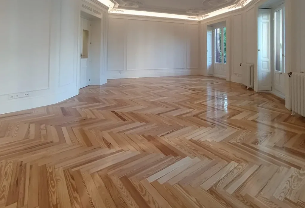 Salón con suelo de espiga de pino melis viejo barnizado en brillo, vivienda en Chamberí (Madrid)