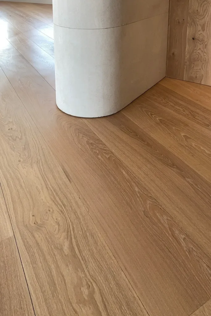Suelo Dinesen Oak Classic recién instalado en torno a un pilar curvo de piedra