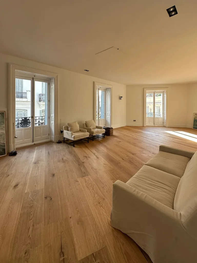 Salón con tres balcones y suelo Dinesen HeartOak encolado sobre suelo radiante, vivienda en el barrio de Justicia, Madrid