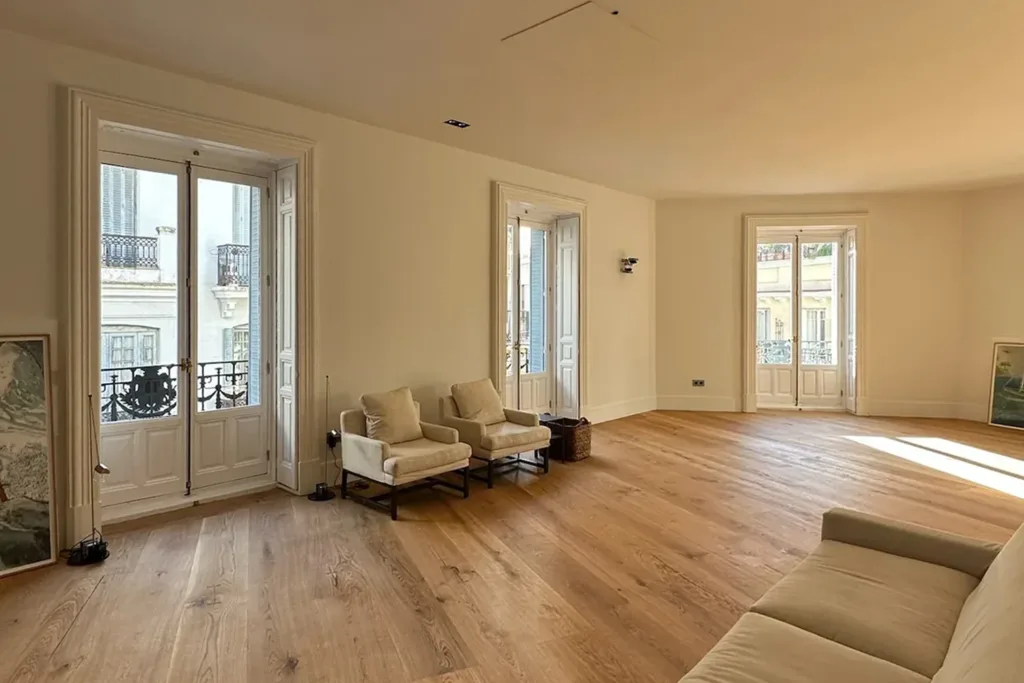 Salón con tres balcones y tarima maciza de tabla ancha Dinesen HeartOak encolada sobre suelo radiante, vivienda en el barrio de Justicia (Madrid)