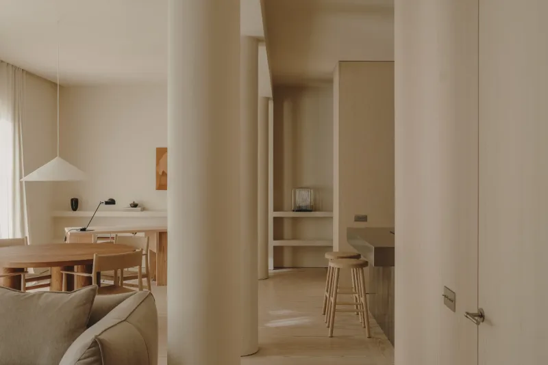 Salón de Casa Ambrose (Madrid) con suelo Dinesen Layers Douglas Classic y cocina al fondo