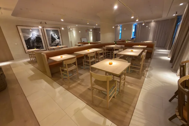 Sala de La Maruca de Azca (Madrid) con suelo Dinesen Oak Natural en anchos combinados, bancada corrida y fotografías de los Picos de Europa