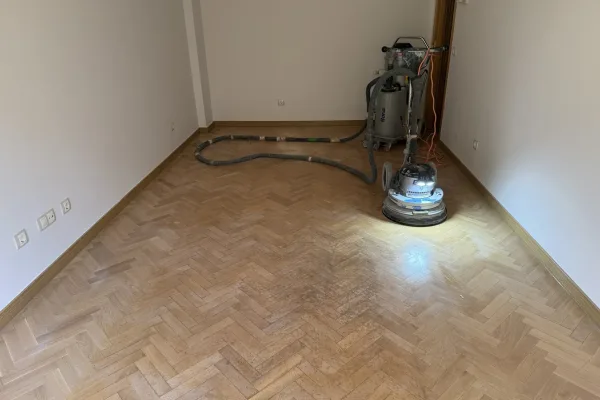La Bona FlexiSand, conectada por manguera al aspirador Bona DCS 70 Lijadora Bona FlexiSand conectada por manguera al aspirador Bona DCS 70 durante el acuchillado de un parquet de roble en espiga, piso con mirador en Madrid